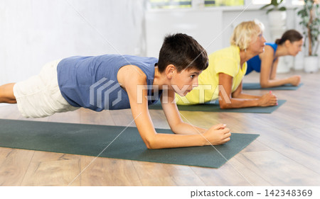 Family in training doing plank exercise to strengthen all abdominal muscle groups Family in training doing plank exercise to strengthen all abdominal muscle groups 142348369