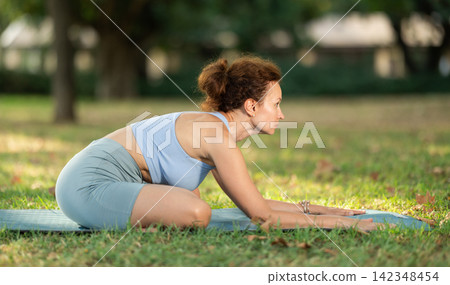 Adult woman doing yoga in lotus position Adult woman doing yoga in lotus position 142348454