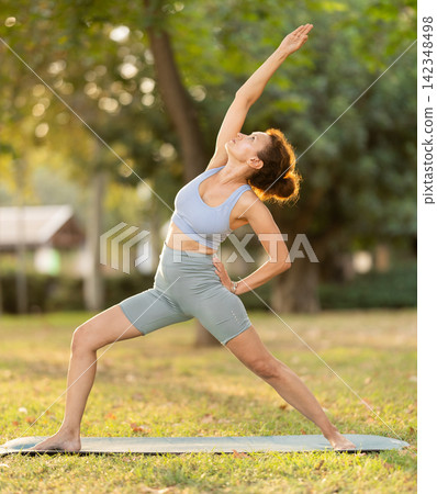 Adult woman doing yoga in park Adult woman doing yoga in park 142348498
