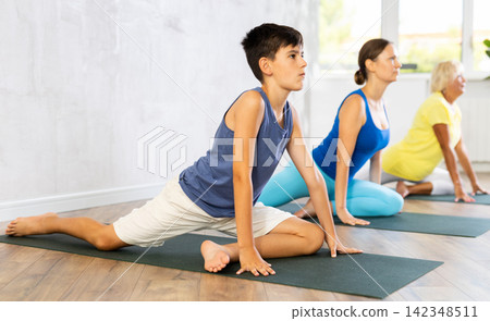 Group of people perform pigeon asana Group of people perform pigeon asana 142348511