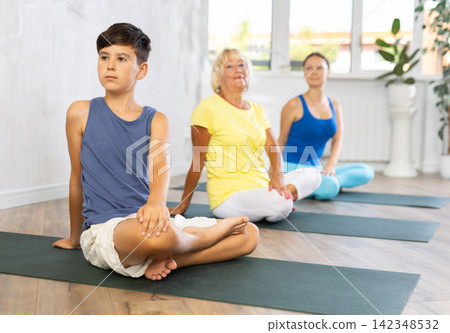 Family three generations do exercise half lotus position Sidhasana with body twist pose Family three generations do exercise half lotus position Sidhasana with body twist pose 142348532