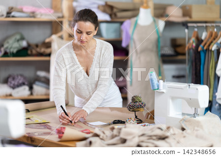 Woman tailor draw dress pattern of product on paper 142348656