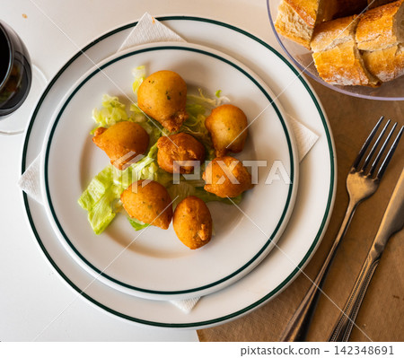 Traditional Portuguese fried codfish balls on lettuce leaves Traditional Portuguese fried codfish balls on lettuce leaves 142348691