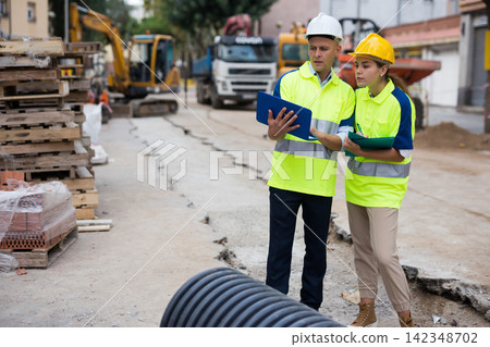 Two architects with laptop discussing construction plan Two architects with laptop discussing construction plan 142348702