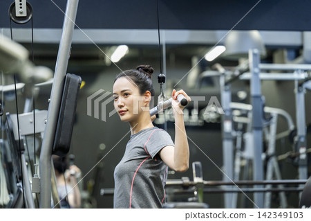 訓練:年輕女子,背闊肌下拉 訓練:年輕女子,背闊肌下拉 142349103