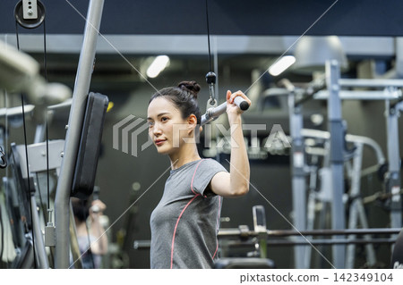 訓練:年輕女子,背闊肌下拉 訓練:年輕女子,背闊肌下拉 142349104
