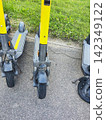 Yellow Electric Scooter Row Parked on Asphalt Sidewalk for Urban Rental Service  142349122