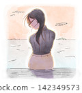 A woman's back as she sits against the backdrop of a sunset. 142349573