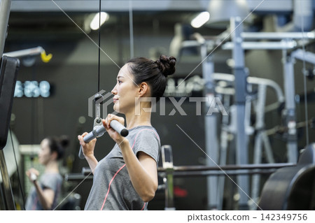 訓練:年輕女子,背闊肌下拉 訓練:年輕女子,背闊肌下拉 142349756
