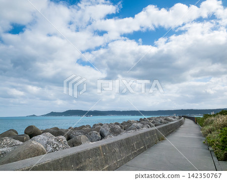 沖繩蔚藍的大海和沿著防波堤延伸的海濱步道 沖繩蔚藍的大海和沿著防波堤延伸的海濱步道 142350767