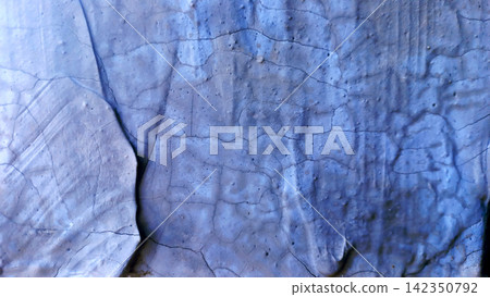 Blue-painted, cracked plaster wall with a relief texture. Blue-painted, cracked plaster wall with a relief texture. 142350792