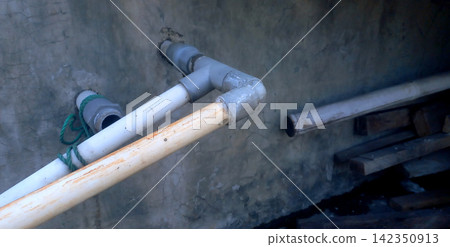 Exposed PVC water pipe installed on a concrete wall. Exposed PVC water pipe installed on a concrete wall. 142350913