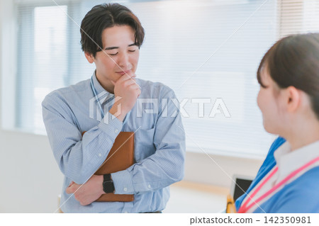 A male colleague, deep in thought with his hand on his chin, is troubled by an office romance. A male colleague, deep in thought with his hand on his chin, is troubled by an office romance. 142350981