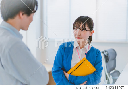 一名女員工在工作中對一名男性同事露出不滿的表情。 一名女員工在工作中對一名男性同事露出不滿的表情。 142351971