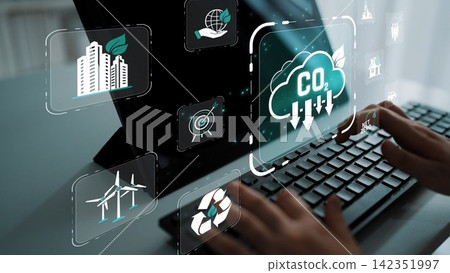 A close-up view of hands typing on a laptop, showcasing a digital interface with icons symbolizing sustainability, CO2 reduction, and renewable energy solutions for a greener future. Sigmoid A close-up view of hands typing on a laptop, showcasing a digital interface with icons symbolizing sustainability, CO2 reduction, and renewable energy solutions for a greener future. Sigmoid 142351997