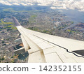 The view of the blue sky and the wing from the airplane window. 142352155
