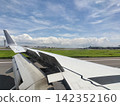 The view of the blue sky and the wing from the airplane window. 142352160