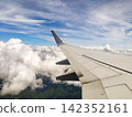 The view of the blue sky and the wing from the airplane window. 142352161