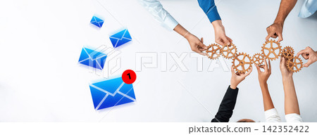 Hands Collaboratively Working with Gears and Email Icons to Represent Teamwork and Communication in a Modern Digital Environment Gantry Hands Collaboratively Working with Gears and Email Icons to Represent Teamwork and Communication in a Modern Digital Environment Gantry 142352422