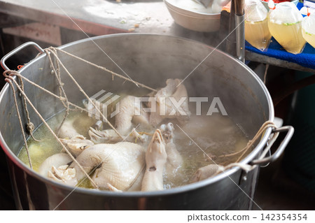Whole chickens boiling large metal stockpot hot broth steam during traditional food preparation busy kitchen Whole chickens boiling large metal stockpot hot broth steam during traditional food preparation busy kitchen 142354354