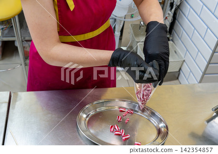 Confectioner Packing Small Hard Candy Pieces into Transparent Plastic Bag Confectioner Packing Small Hard Candy Pieces into Transparent Plastic Bag 142354857