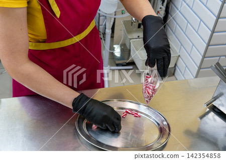 Confectioner Filling Clear Plastic Cone Pouch with Small Striped Hard Candies Confectioner Filling Clear Plastic Cone Pouch with Small Striped Hard Candies 142354858