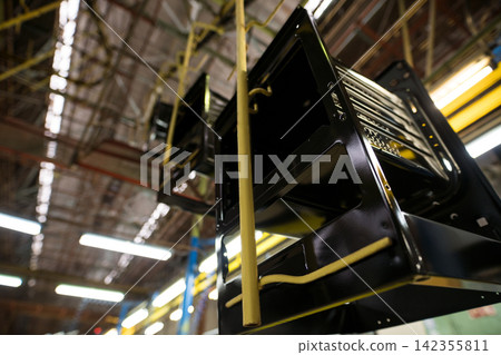 Black metal appliance chassis on factory assembly line with yellow conveyor rails Black metal appliance chassis on factory assembly line with yellow conveyor rails 142355811