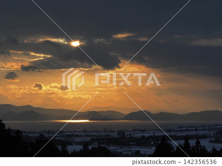 冬日傍晚,夕陽透過豬苗代湖上空的雲層縫隙灑下,湖面泛起橙色的光芒,構成了一幅引人注目、美不勝收的景象。 冬日傍晚,夕陽透過豬苗代湖上空的雲層縫隙灑下,湖面泛起橙色的光芒,構成了一幅引人注目、美不勝收的景象。 142356536