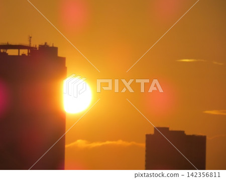 從高崎市觀音山看到的日出:太陽從建築物之間升起,晨曦將城市籠罩在橘色的光芒中。 從高崎市觀音山看到的日出:太陽從建築物之間升起,晨曦將城市籠罩在橘色的光芒中。 142356811