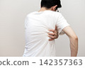 A middle-aged man's back view, showing he suffers from dry skin and itchy back due to heat rash. 142357363