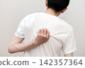 A middle-aged man's back view, showing he suffers from dry skin and itchy back due to heat rash. 142357364