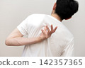 A middle-aged man's back view, showing he suffers from dry skin and itchy back due to heat rash. 142357365