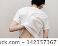 A middle-aged man's back view, showing he suffers from dry skin and itchy back due to heat rash. 142357367