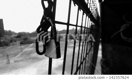 Padlock and chain on a wire fence Padlock and chain on a wire fence 142357624