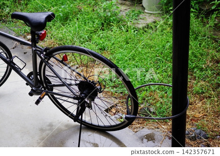 下雨天,一輛自行車被遺棄在公園。 下雨天,一輛自行車被遺棄在公園。 142357671