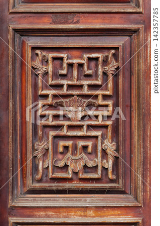Antique carved wooden door panel with a geometric Asian motif Antique carved wooden door panel with a geometric Asian motif 142357785