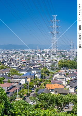 A vast residential area and power transmission towers viewed from a hilltop in Hino City, Tokyo. A vast residential area and power transmission towers viewed from a hilltop in Hino City, Tokyo. 142357867