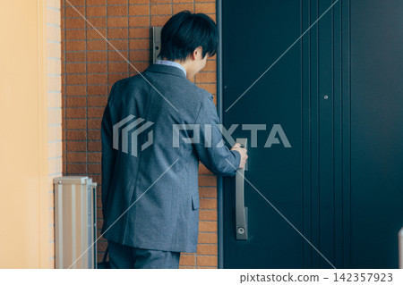 A man unlocks the door at the front door. A man unlocks the door at the front door. 142357923