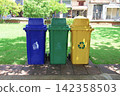Three colorful recycling trash bins placed in a public park 142358503