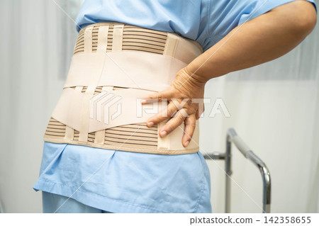 Asian senior pain back wearing elastic support belt with walker. Asian senior pain back wearing elastic support belt with walker. 142358655