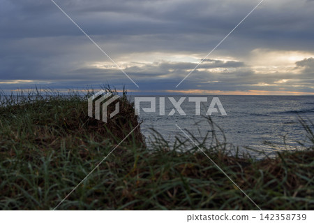 Stora Sandvik beach bordered by grassy dunes above a dark Atlantic cove, Iceland Stora Sandvik beach bordered by grassy dunes above a dark Atlantic cove, Iceland 142358739