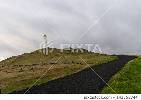 Reykjanes Lighthouse standing among rough grass beside a sloping footpath, Iceland Reykjanes Lighthouse standing among rough grass beside a sloping footpath, Iceland 142358744