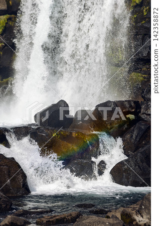 Oxararfoss waterfall towering between fractured rift walls in sunlight, Thingvellir, Iceland Oxararfoss waterfall towering between fractured rift walls in sunlight, Thingvellir, Iceland 142358872