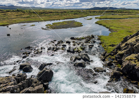 Oxara River moving gently through a broad rocky wetland, Thingvellir National Park, Iceland Oxara River moving gently through a broad rocky wetland, Thingvellir National Park, Iceland 142358879