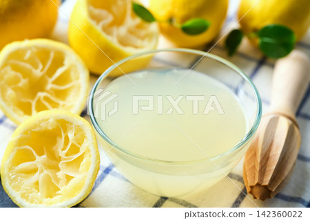homemade lemon juice in small bowl on dark table, selective focus. freshly squeezed lemon juice . 142360022