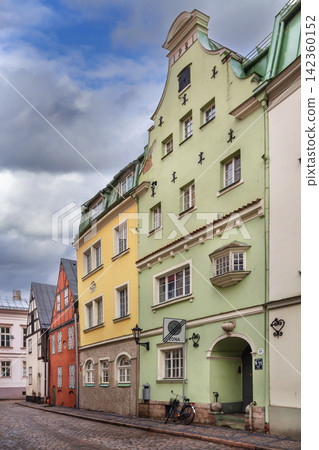 Historic street with colorful houses in Old Town of Riga, Latvia. Beautiful green facade and traditional medieval architecture Historic street with colorful houses in Old Town of Riga, Latvia. Beautiful green facade and traditional medieval architecture 142360152