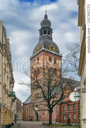 View of Riga Cathedral tower and small square on a cloudy February day, Latvia. Historic Lutheran cathedral and city street View of Riga Cathedral tower and small square on a cloudy February day, Latvia. Historic Lutheran cathedral and city street 142360153