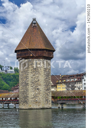 Octagonal Wasserturm water tower and Chapel Bridge on Reuss river in Lucerne, Switzerland. Cloudy June sky in summer day Octagonal Wasserturm water tower and Chapel Bridge on Reuss river in Lucerne, Switzerland. Cloudy June sky in summer day 142360210