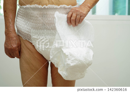 Asian senior woman patient wearing adult incontinence diaper pad in hospital. Asian senior woman patient wearing adult incontinence diaper pad in hospital. 142360616