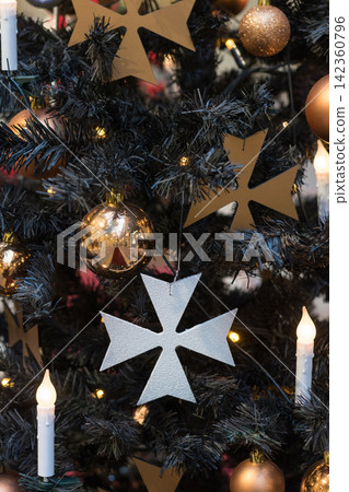 Christmas tree with gothic dark decor, golden balls, candles on dark in interiors. Xmas. Close up. 142360796